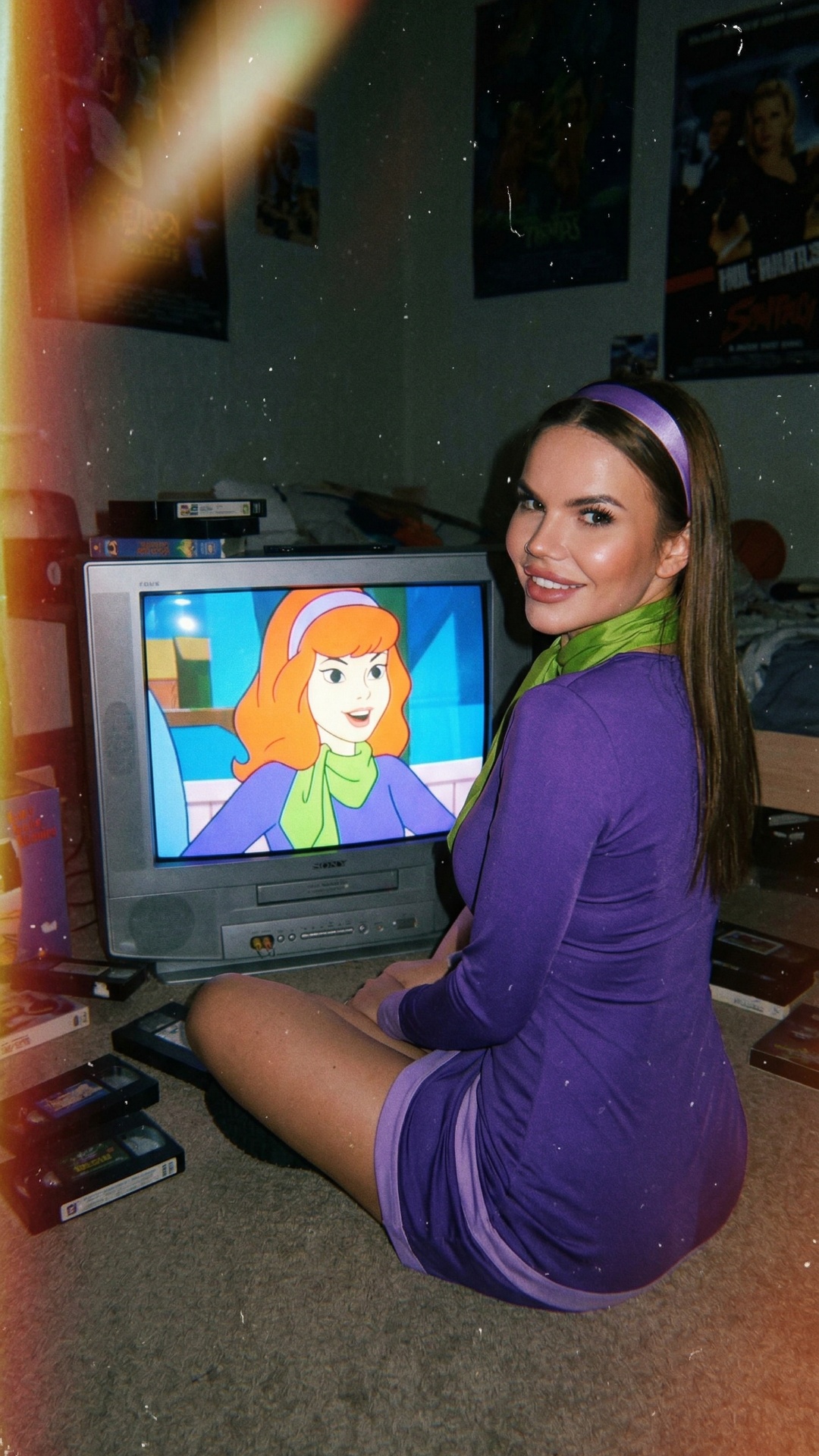 Cinematic video, young woman sitting alone on a cozy couch in a dim living room at night. TV in f...