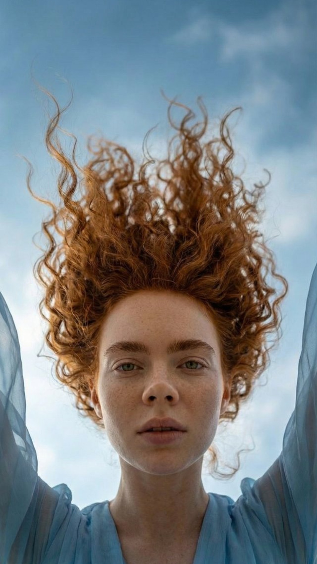 The woman is captured mid-fall in open sky.

Her downward motion gradually slows into an ultra sl...