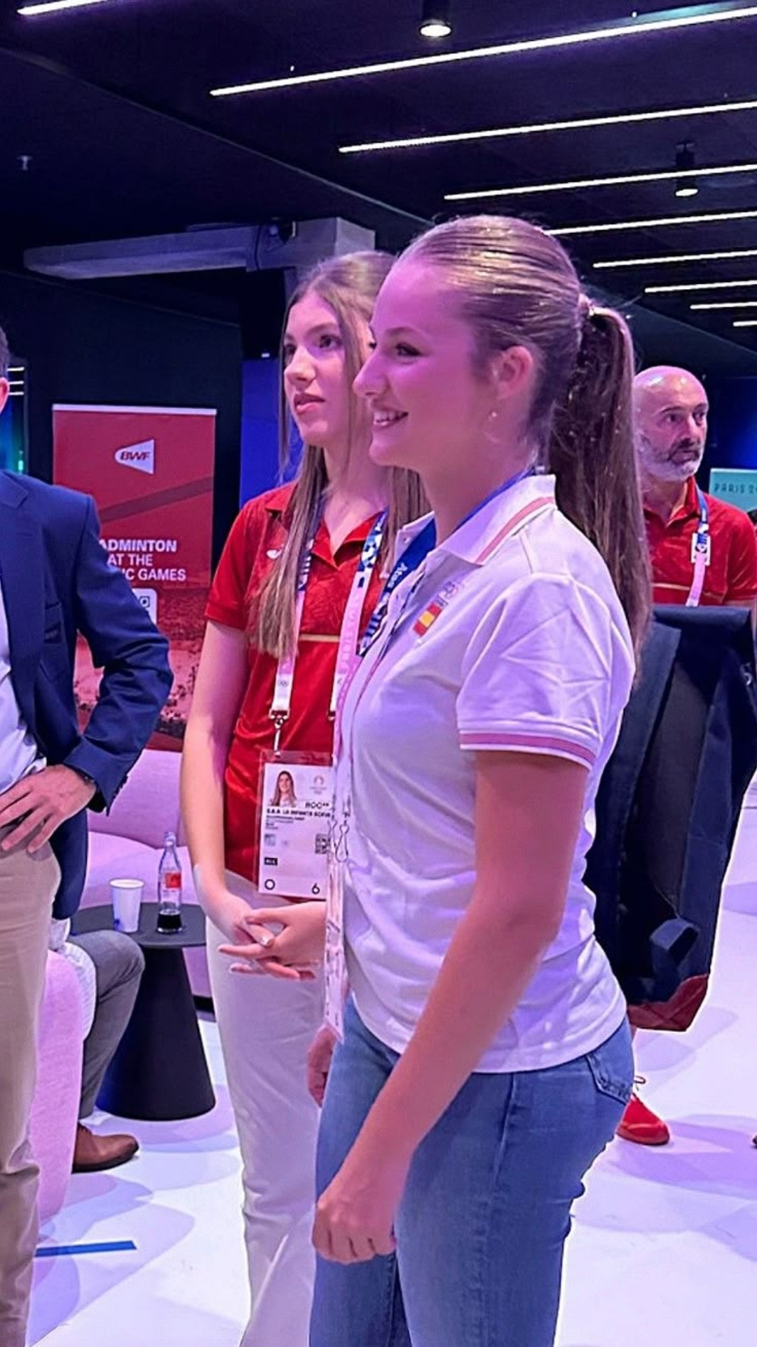 The Blonde woman turns around, look at the woman behind her in red. The woman behind the Blonde w...