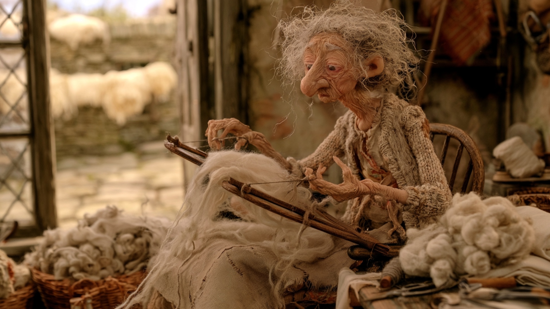 The woman lifts one wooden carder loaded with fluffy wool, transfers the soft layer onto the seco...
