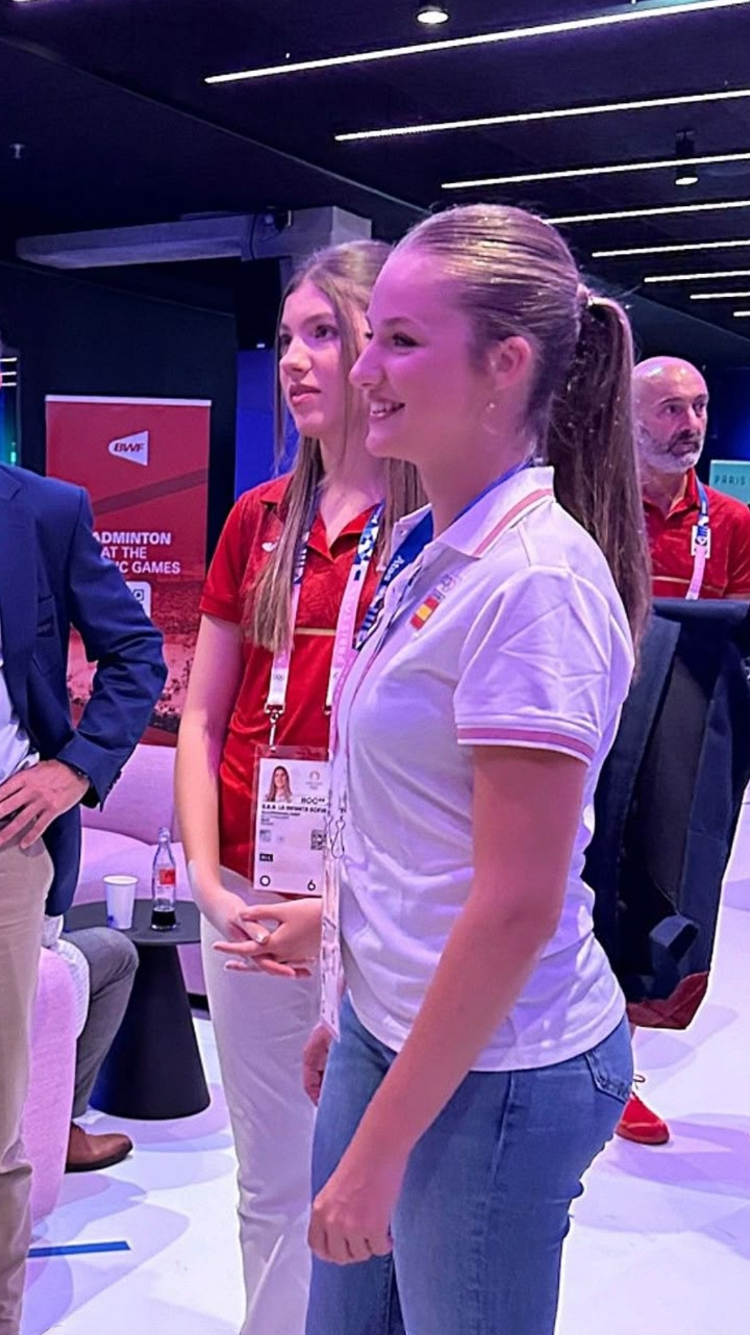 The Blonde woman turns around, look at the woman behind her in red. The woman behind the Blonde w...