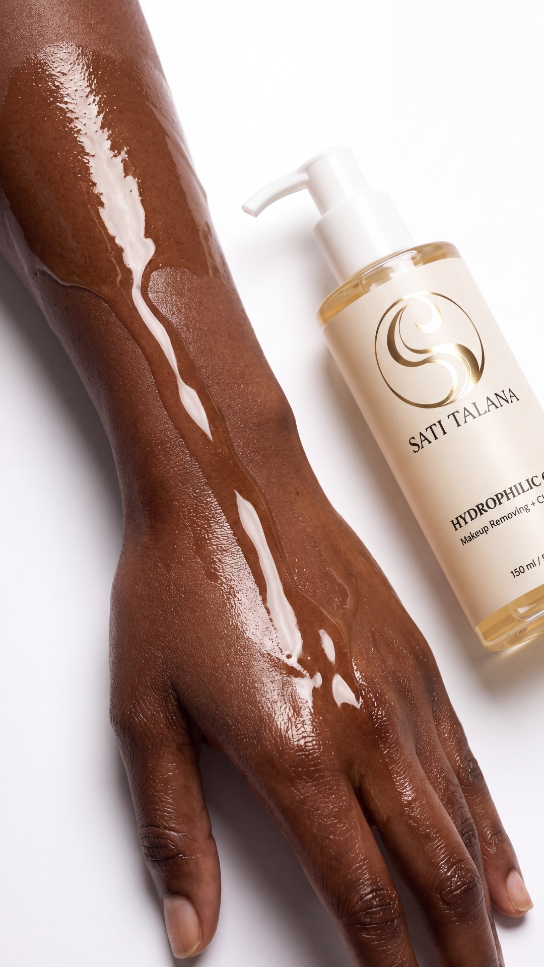 Camera slowly tracks sideways along the glossy dark-skinned hand covered in golden oil. Natural h...