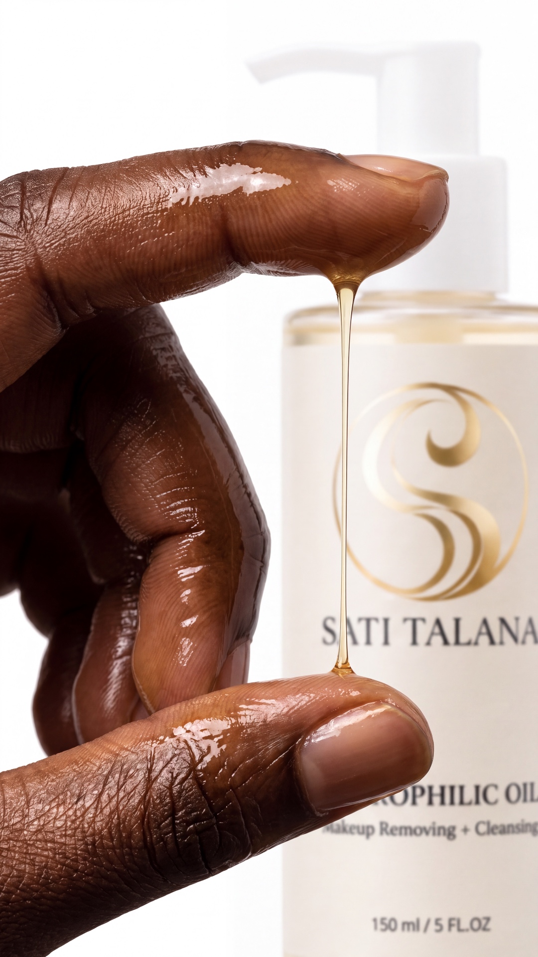 Camera slowly moves around the hands as they gently rub the golden oil together. Natural handheld...