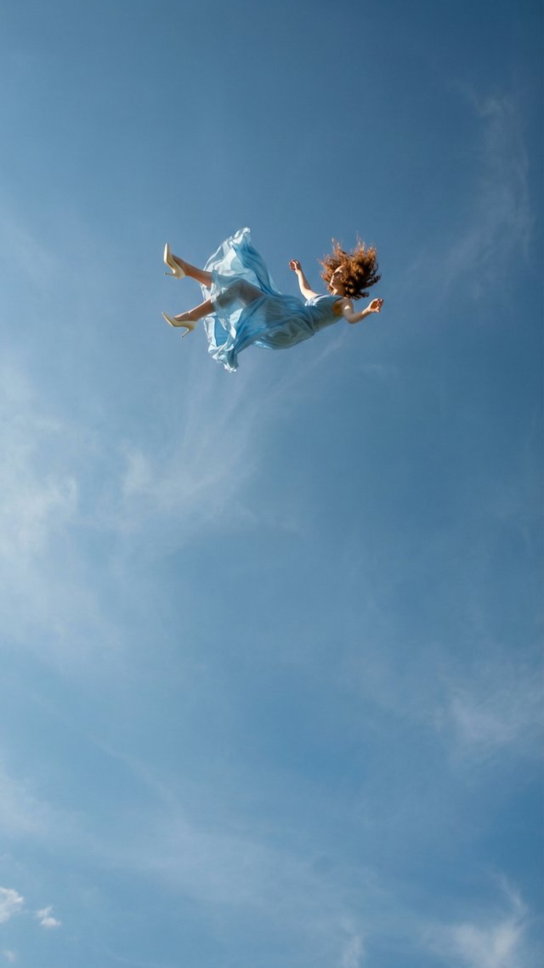Scene begins with a vast open blue sky, extreme low angle from ground looking upward. A small dis...