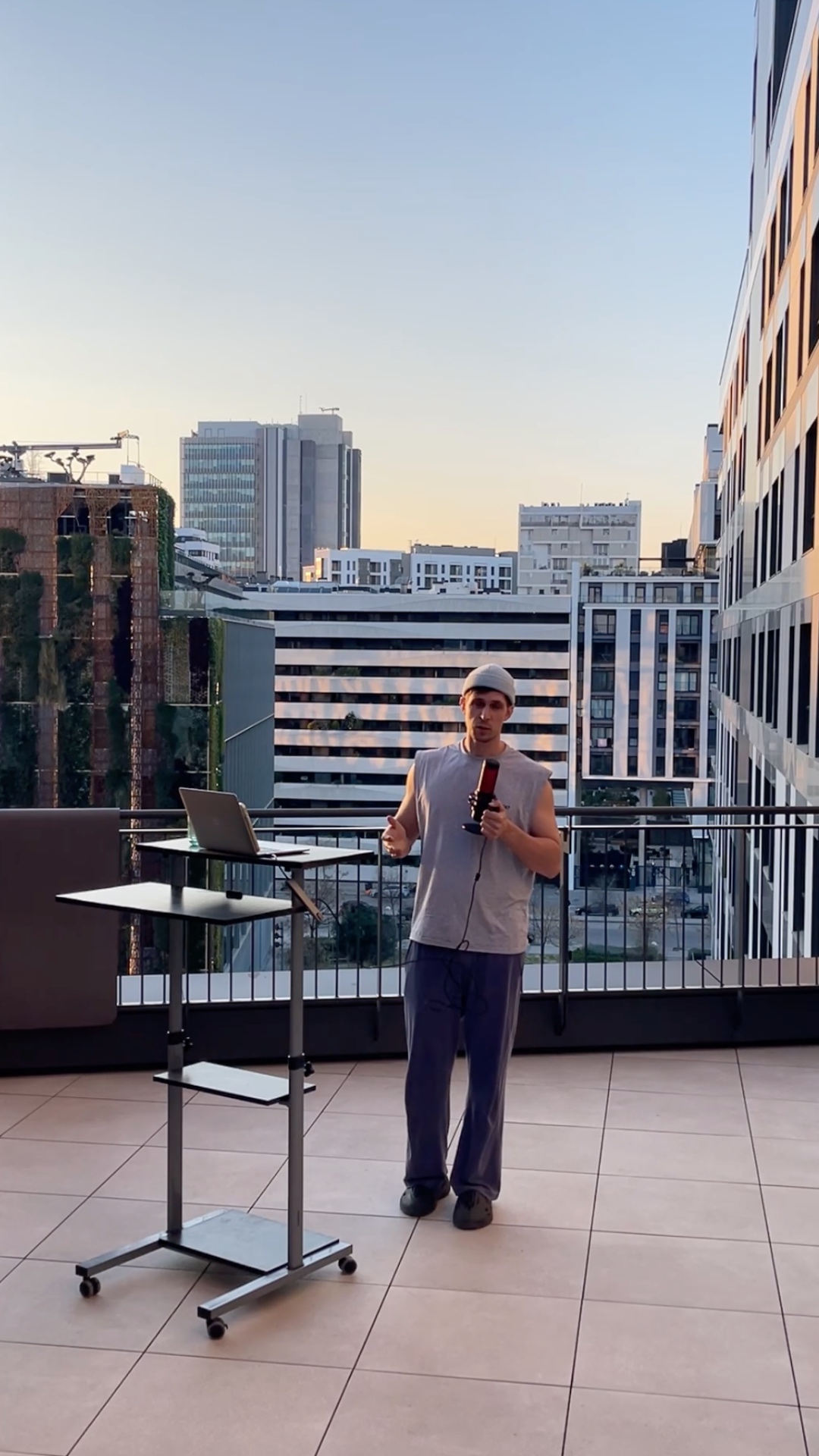 A man on a rooftop terrace walks directly to the edge near the railing and jumps down off the ter...