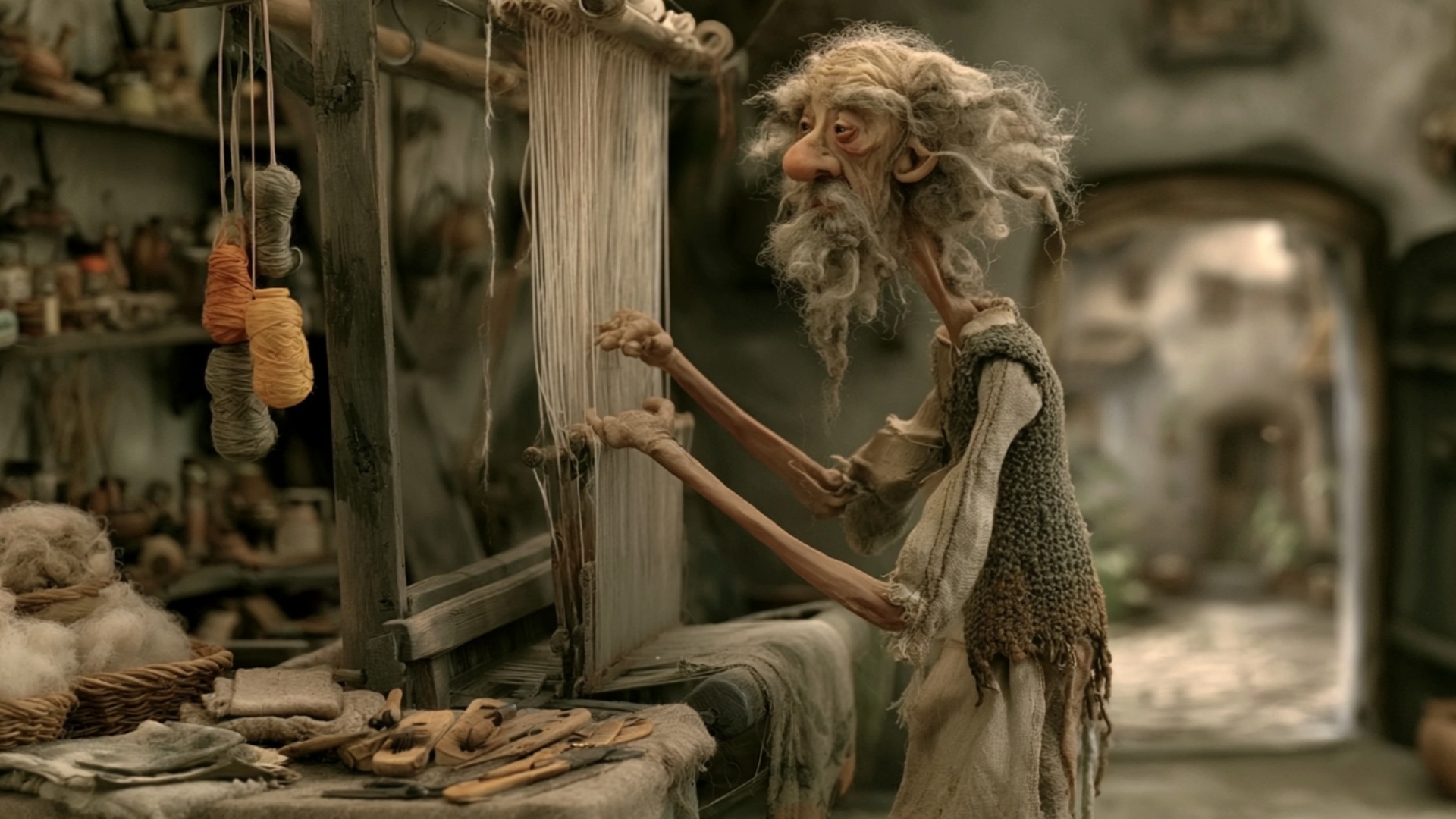 The elderly weaver pulls one warp thread downward and hooks it into place on the loom. He tests t...