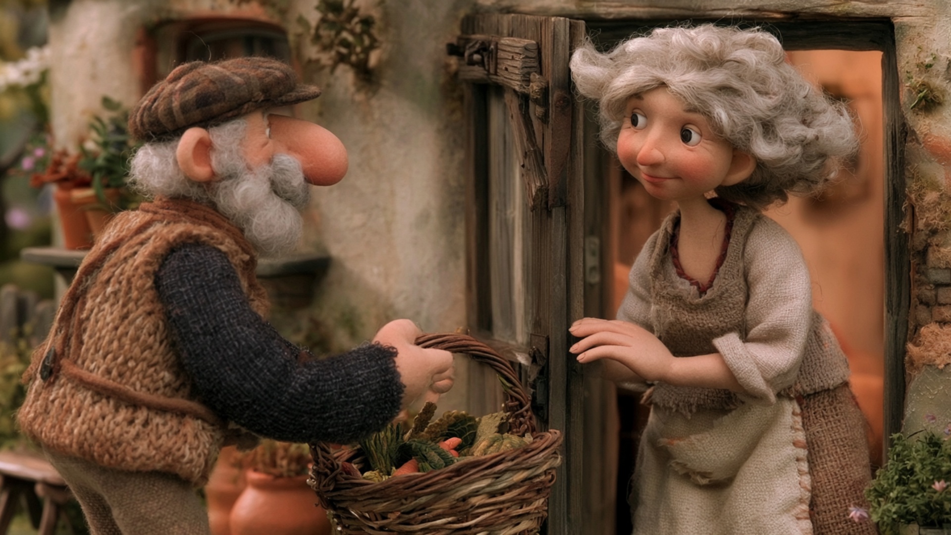 The elderly man steps forward and clearly offers the heavy vegetable basket toward the woman in t...