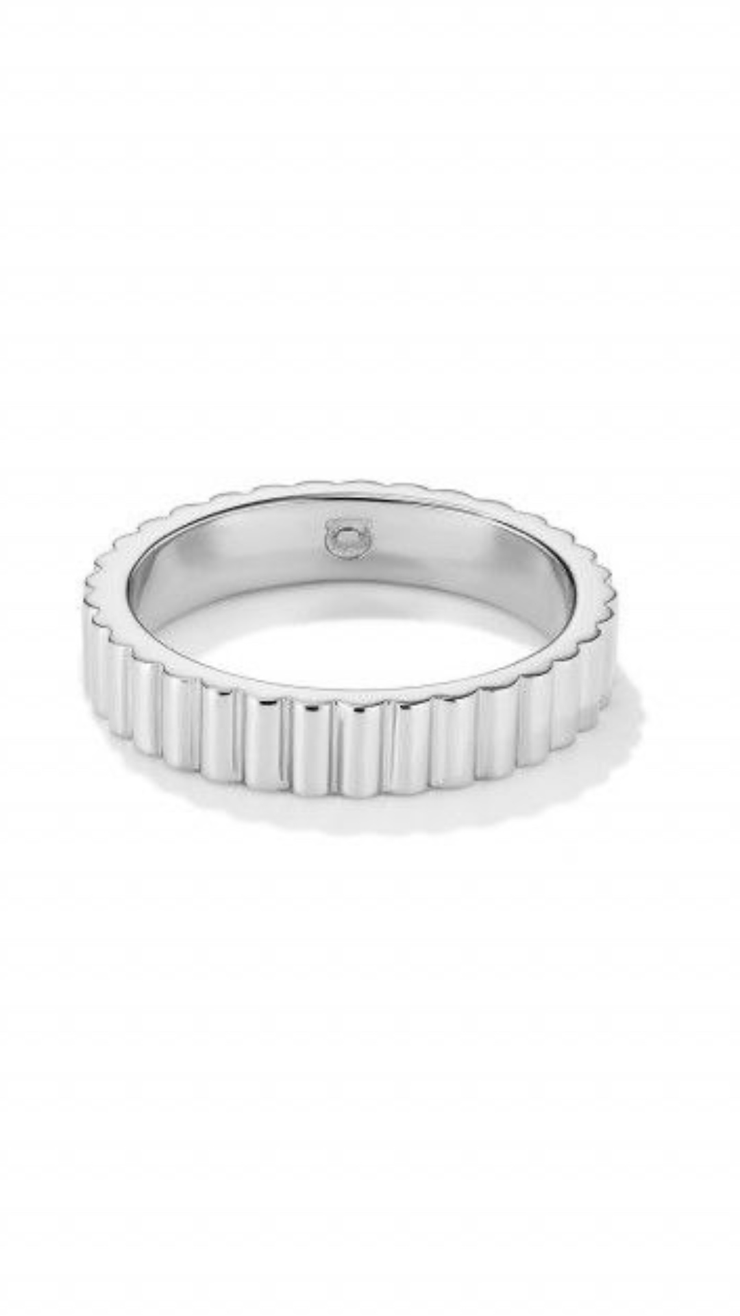 Ultra-realistic cinematic scene. A shiny silver ring with vertical grooves lies on a brushed stee...