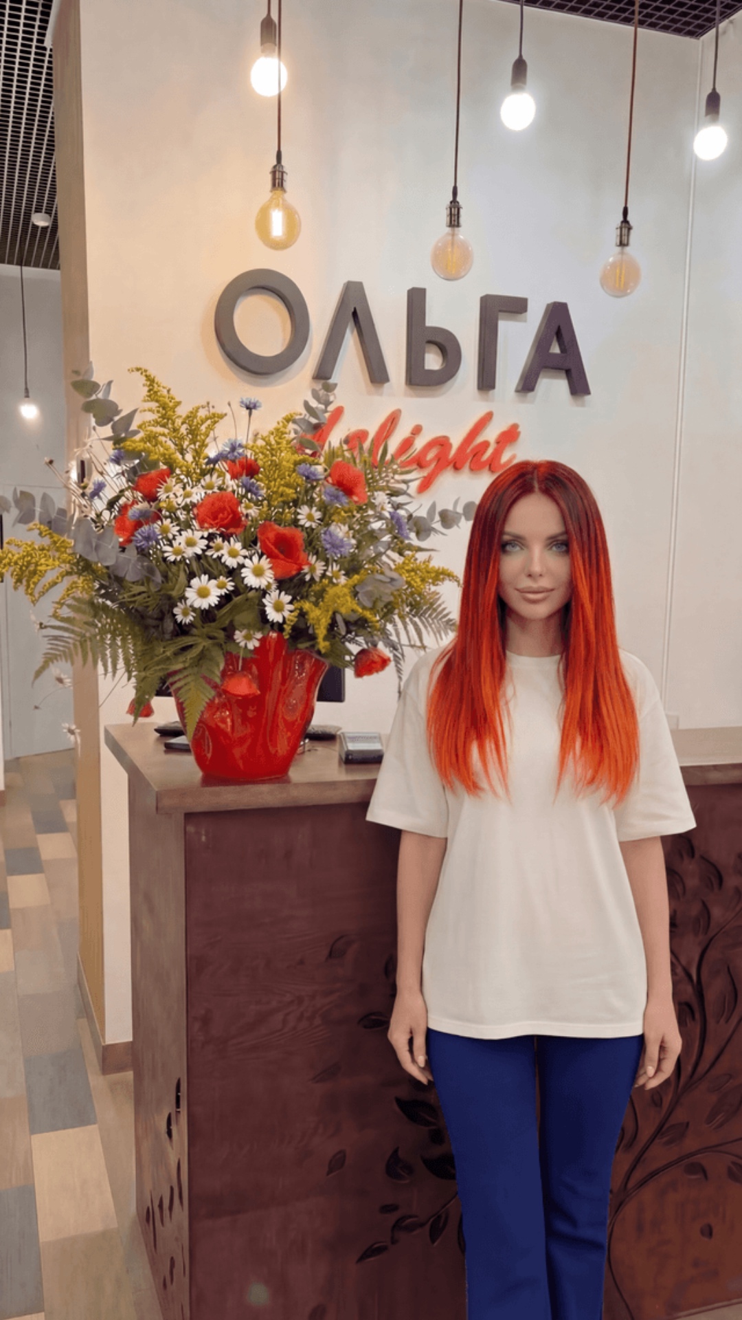 делает взмах головой и смеется