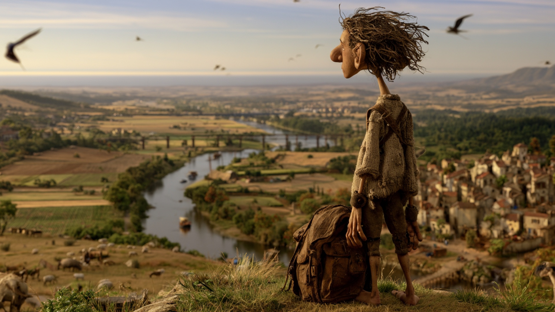 The traveler stays at the edge of the hill beside the large worn backpack, facing the immense riv...