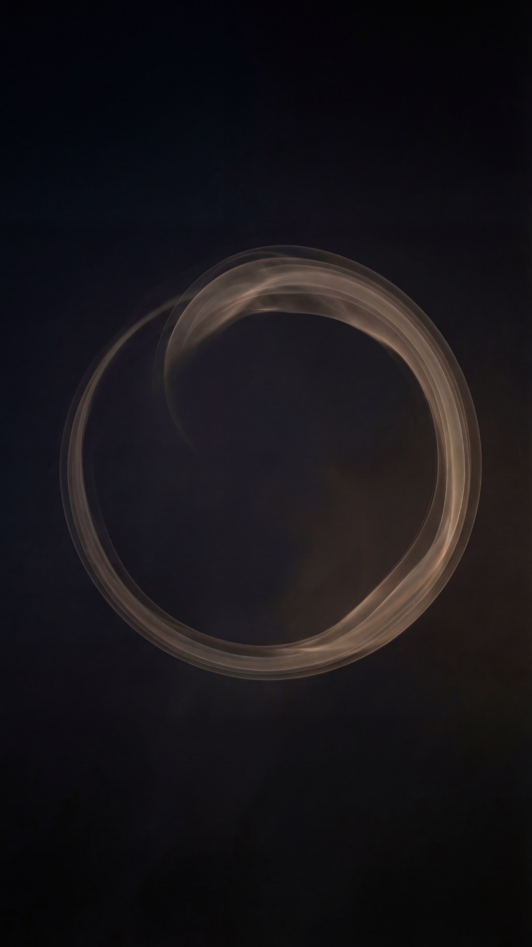 A soft glowing orb of light forming a circle on a pure black background. It rotates extremely slo...