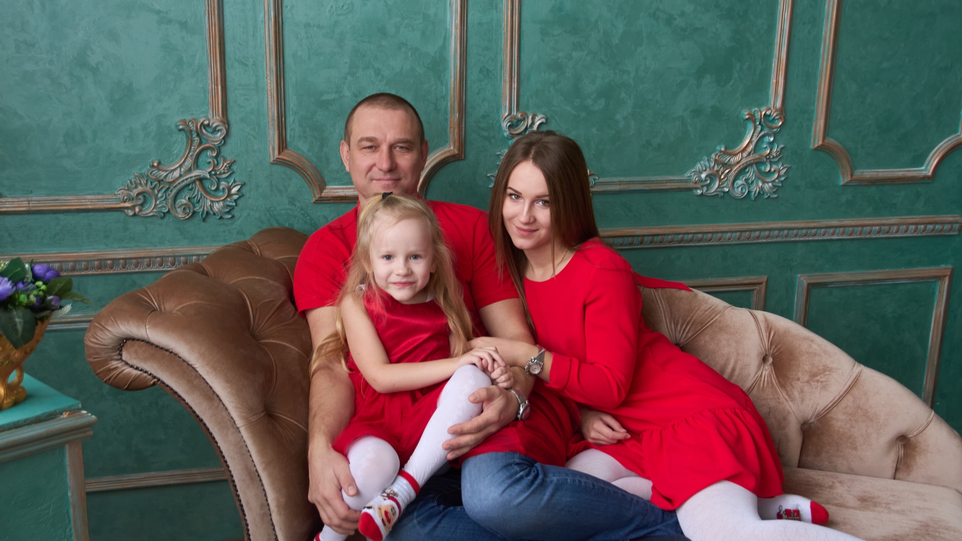 Father and his daughters sitting on a couch, laughing and chatting. Cozy home interior, natural l...