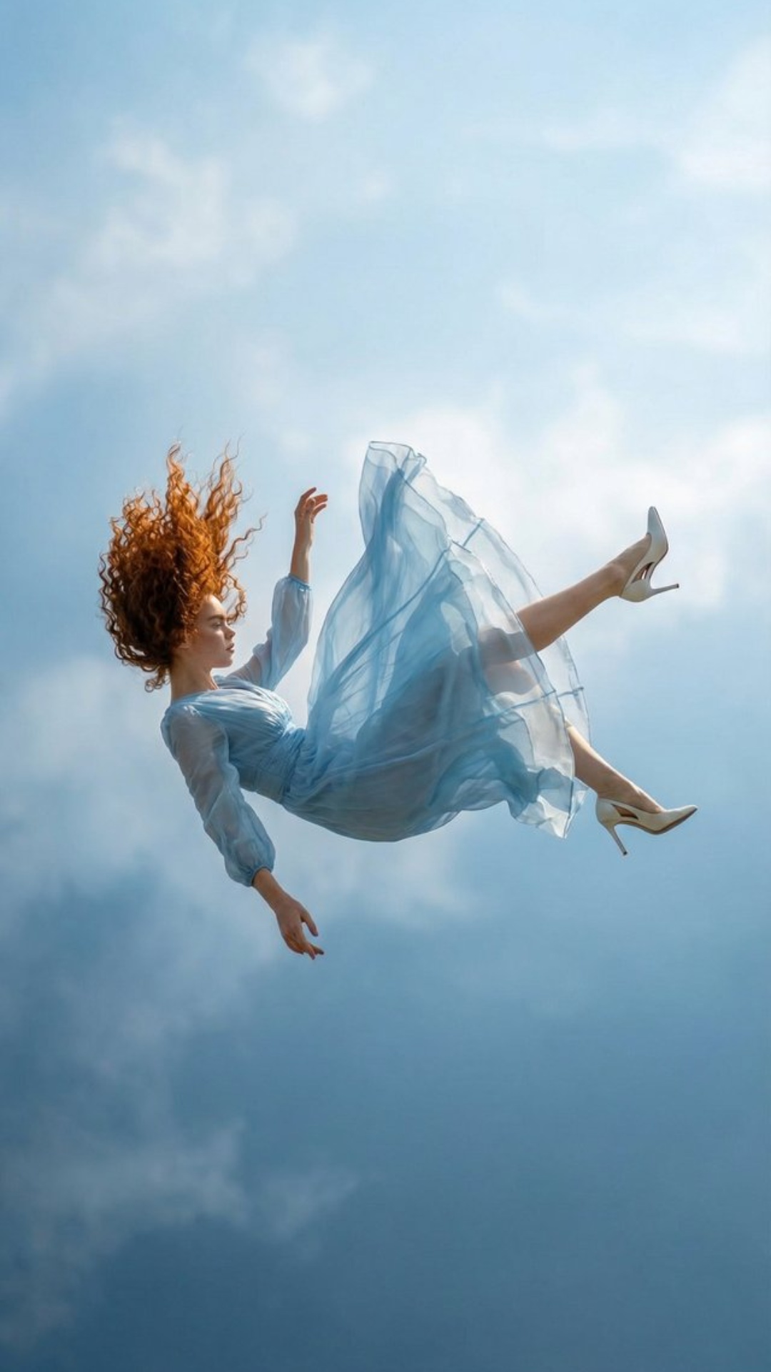 The woman is captured mid-fall in open sky.

Her downward motion gradually slows into an ultra sl...