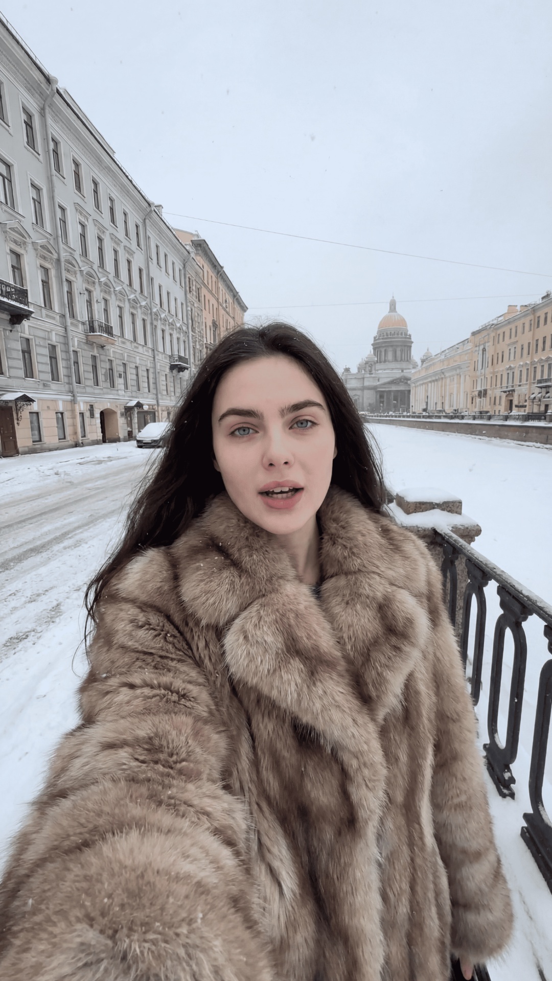 девушка 25 лет держит телефон в руке, снимает себя на телефон и говорит по русски без акцента нем...