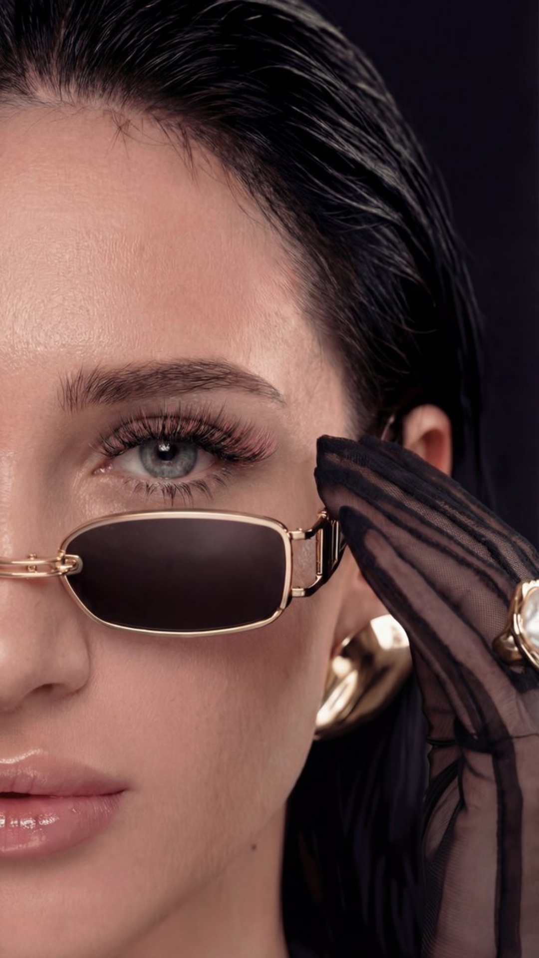 девушка надевает очки на голову. она смотрит уверено в камеру и моргает, рот не подвижен.