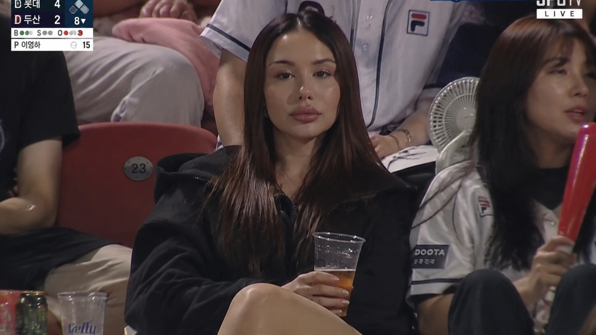 Realistic sports broadcast screenshot-style documentary video set in the spectator stands of a Ko...